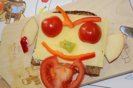 Brotgesicht mit Käse, Tomaten und Paprika